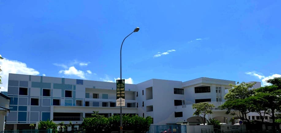 St. Anthony's Canossian Primary School seen from Bedok North Avenue 4, its blue and white classroom blocks under a clear sky