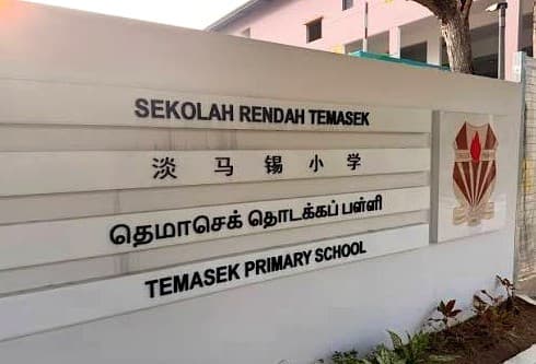 Entrance sign of Temasek Primary School, naming the school in English, Chinese, Malay and Tamil beside its crest